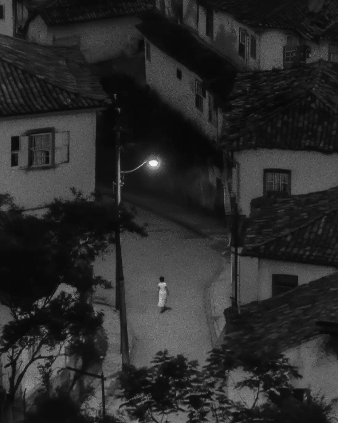Rua vazia à noite, iluminada por um único poste